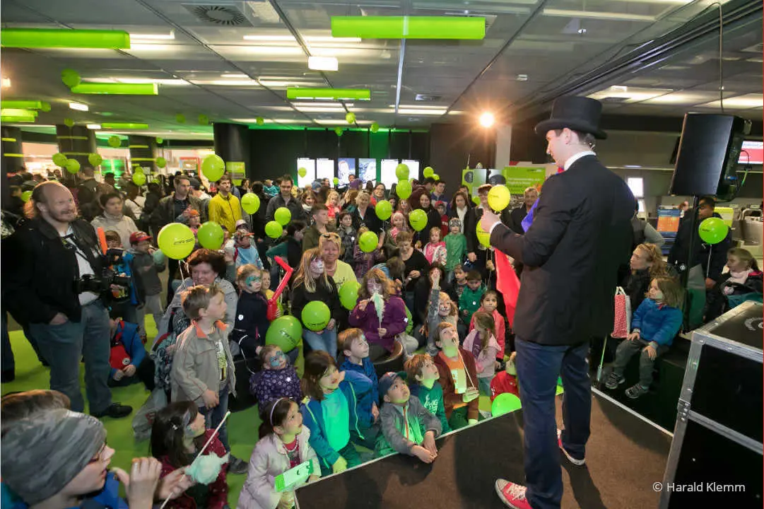 Kinderzauberer Philipp Kainz mit Zylinder unterhält zahlreiche Kinder bei einem Event