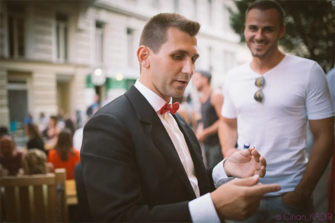 Zauberer Philipp Kainz zeigt einen Close-up-Trick für einen staunenden Gast im Freien